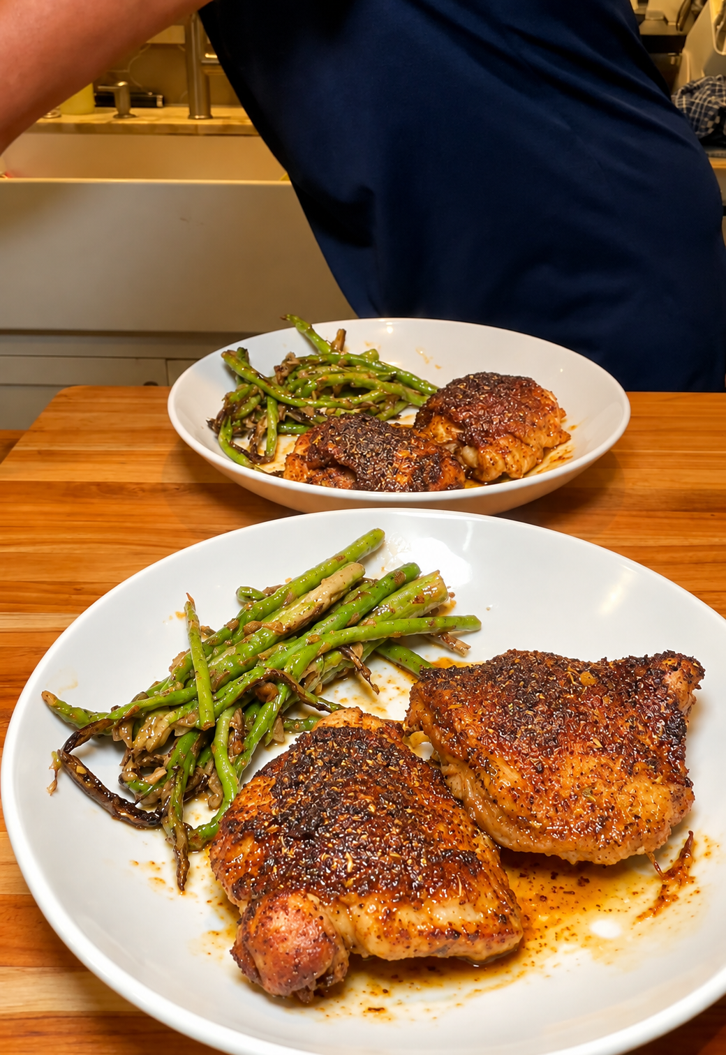 Two cooked bone-in thighs plated beside asparagus